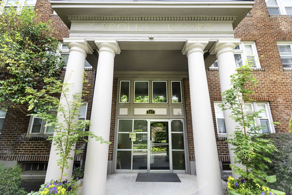 The Front of Carolina Court Apartment Homes' Brick Building with Large White Columns at Carolina Court, WA 98109