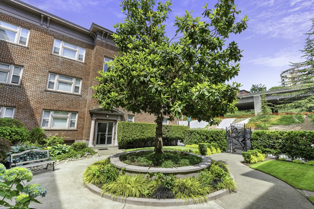 Lush Resident Courtyard in Front of a Brick Apartments at Carolina Court, Seattle, WA