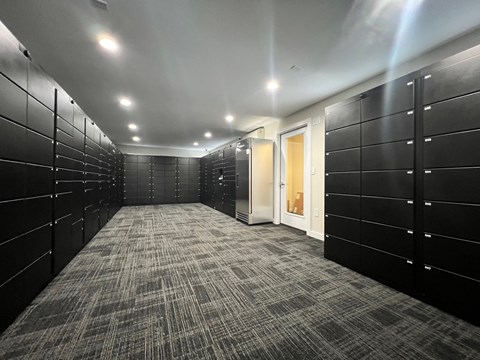 A long hallway with black lockers and carpeted floors.
