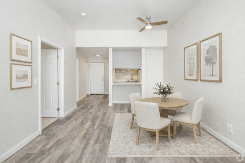 A dining room with a table and chairs.