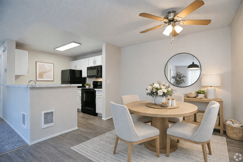 A dining room with a round table and chairs.