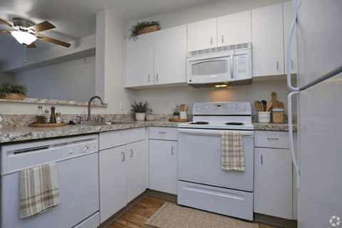 A kitchen with white cabinets and appliances.