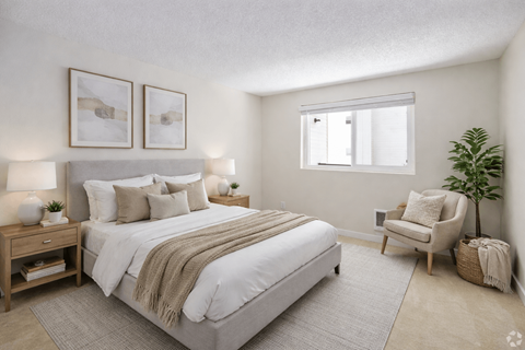 A bedroom with a large bed and a chair.