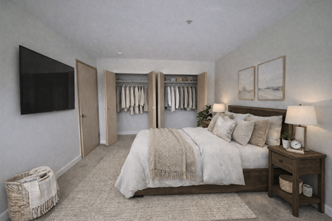 A bedroom with a large bed and a TV on the wall.
