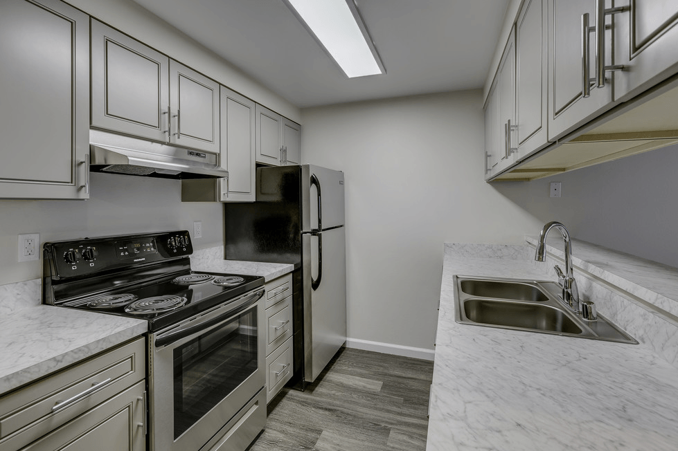 A kitchen with a stove, oven, and sink.
