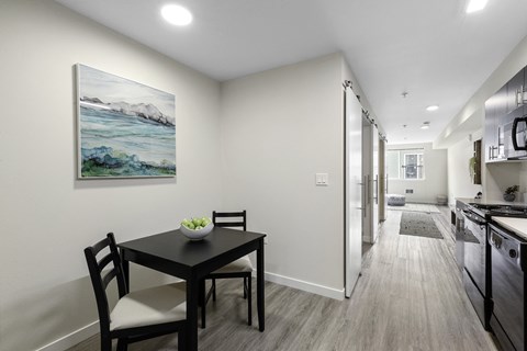 a dining area with a table and chairs and a kitchen in the background at Arabella Apartment Homes, Shoreline, WA