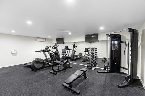 a gym with cardio equipment and a flat screen tv  at Casa Blanca Apartment Homes, Washington, 98204