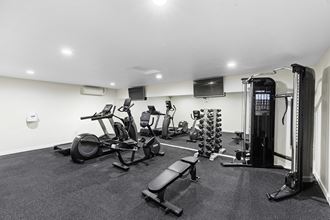 a gym with cardio equipment and a flat screen tv a gym with cardio equipment and a flat screen tv at Casa Blanca Apartment Homes, Washington, 98204 - Photo Gallery