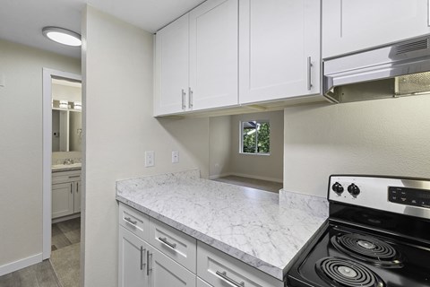 the kitchen of a home with white cabinets and a stove