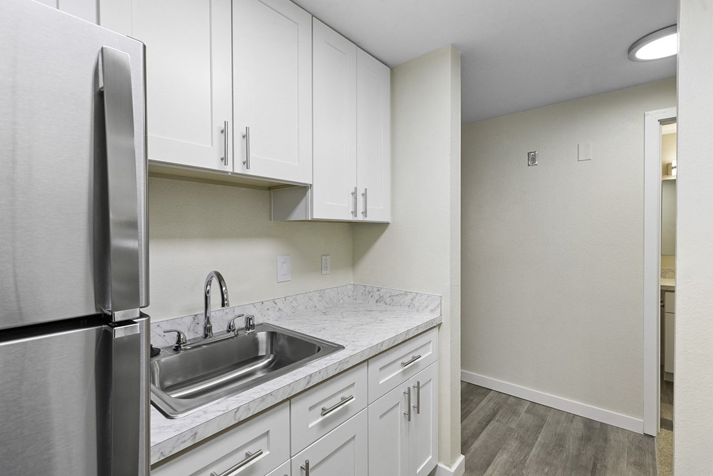 a kitchen with white cabinets and stainless steel appliances at Casa Blanca Apartment Homes, Washington