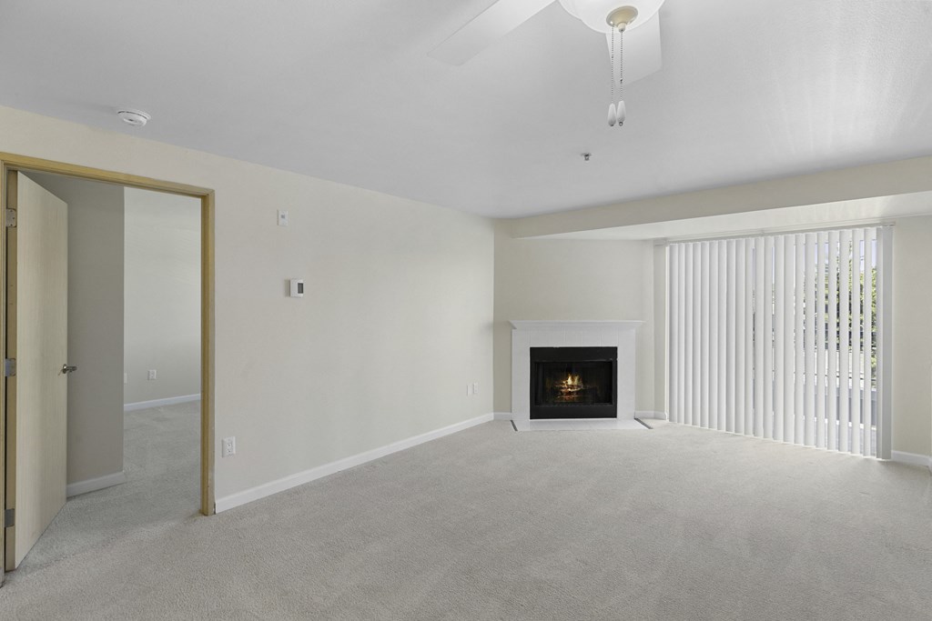 Spacious Living Area with a fireplace, cozy carpeting, and sliding glass doors at Casa Blanca Apartment Homes, Washington