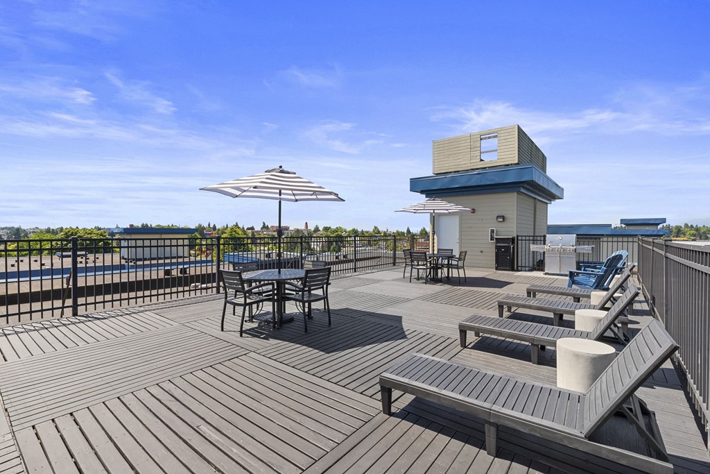a large rooftop deck with tables and umbrellas at Guinevere Apartment Homes, Seattle