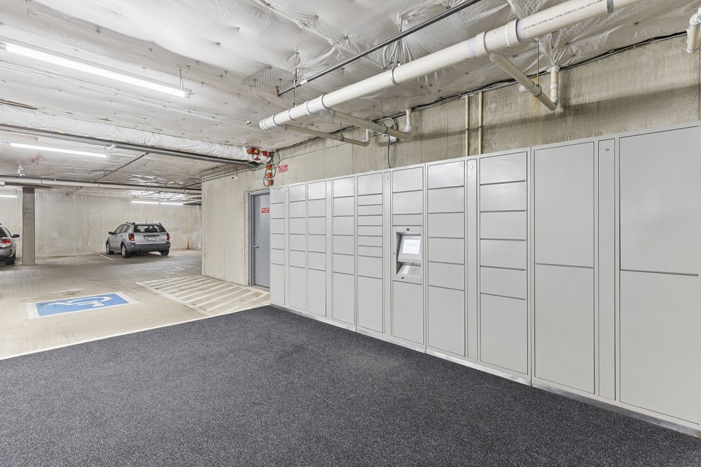 a row of package receiving lockers in the resident parking garage at Guinevere Apartment Homes, Seattle, Washington 98103
