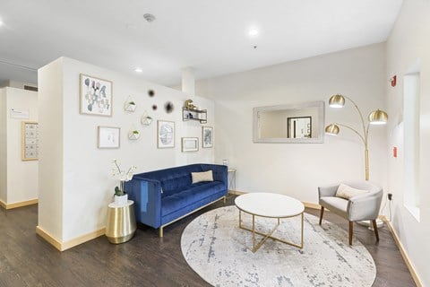 a living room with a blue couch and a round table