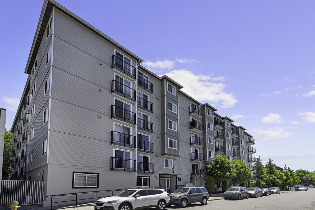 a large apartment building with cars parked in front of it at King Arthurs Court, Seattle, 98125