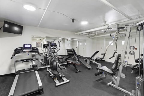 a gym with treadmills and other exercise equipment on the floor