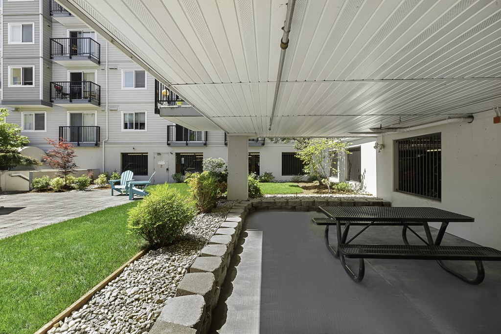 a covered patio with a picnic table and chairs at King Arthurs Court, Seattle