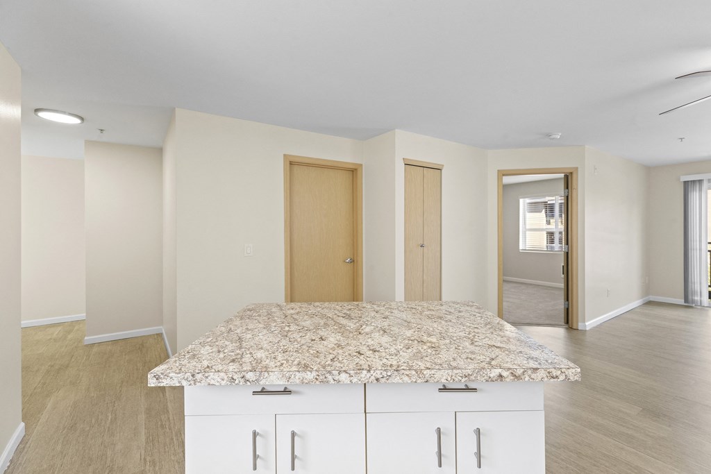 View from the Kitchen showing island with cabinets and view of living area at Promenade at the Park Apartment Homes, Seattle, 98125