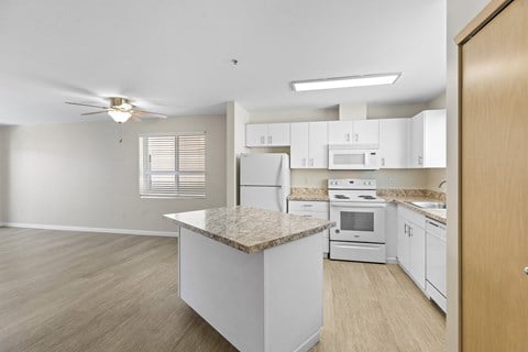 a kitchen with white appliances and a granite counter top