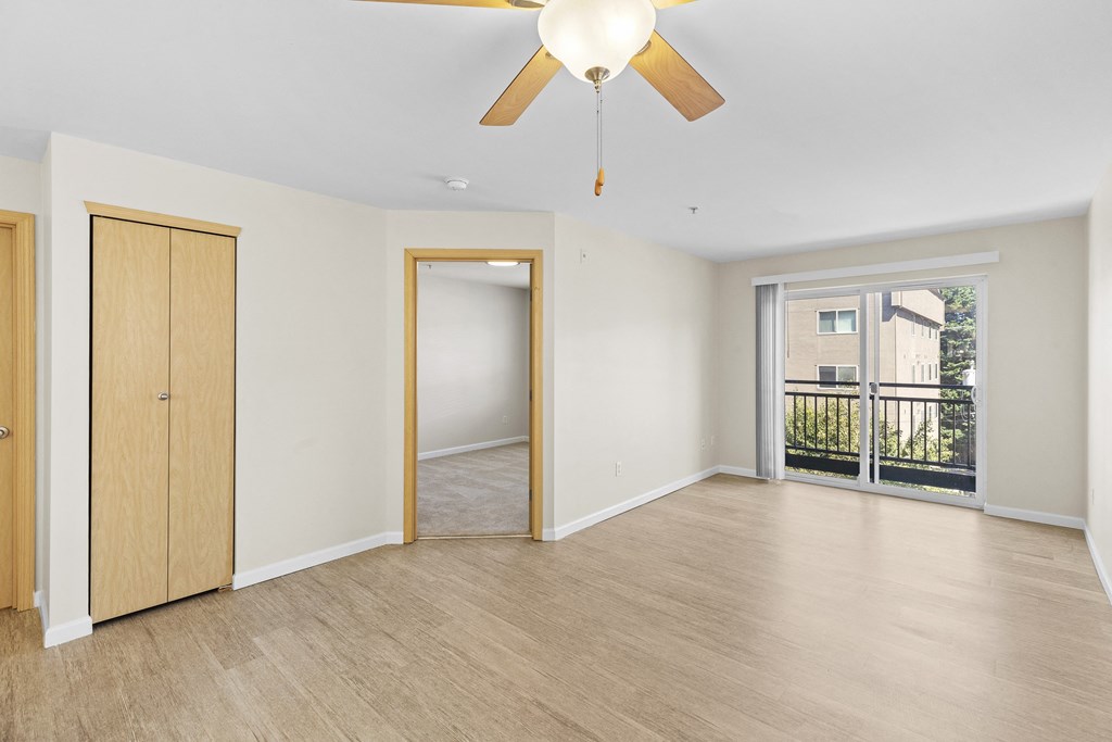 View from the Living Space with a ceiling fan of the wide windows and cozy bedroom at Promenade at the Park Apartment Homes, Seattle, Washington 98125