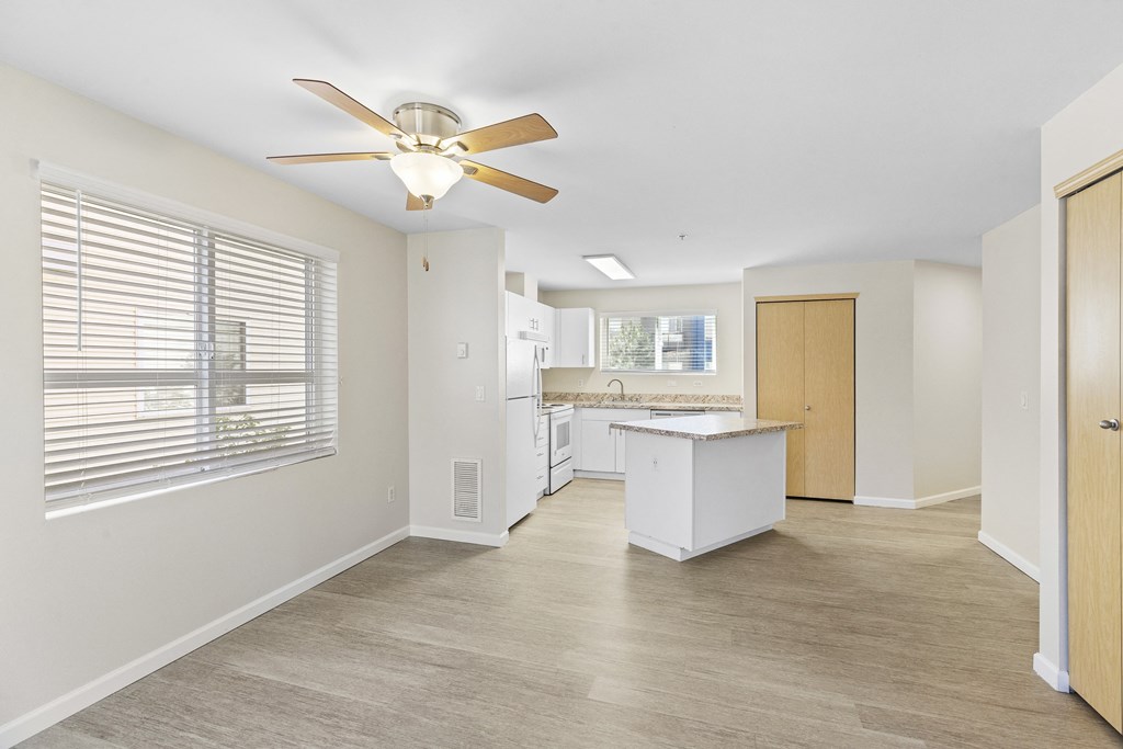 Spacious kitchen and living room with a large window and a ceiling fan at Promenade at the Park Apartment Homes, Washington, 98125