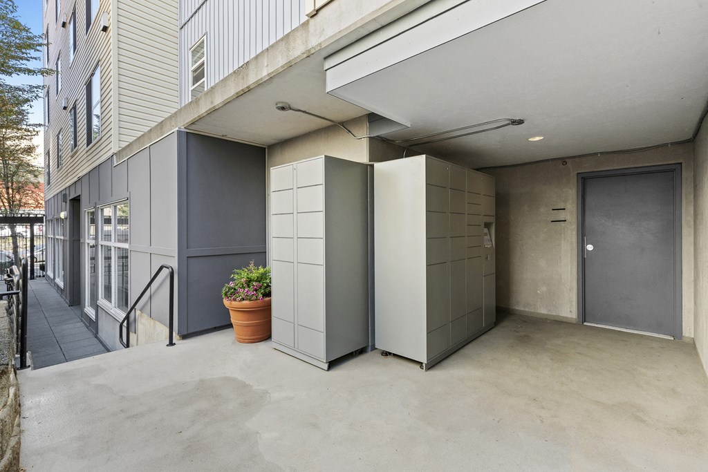 a private entrance area two package lockers and a potted plant on the side of a building at Promenade at the Park Apartment Homes, Seattle, Washington 98125