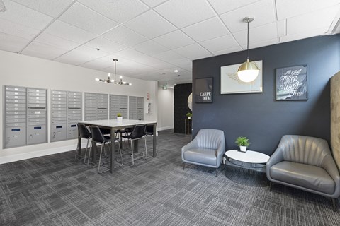 Cozy Lobby Area with a table and chairs and convenient mailboxes on the wall at Villaggio Apartment Homes, Tacoma, 98402
