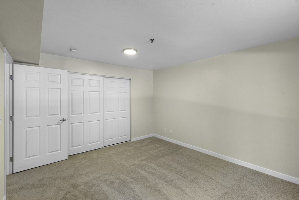 a bedroom with two closets and a carpeted floor at West Mall Place Apartment Homes, Washington, 98208