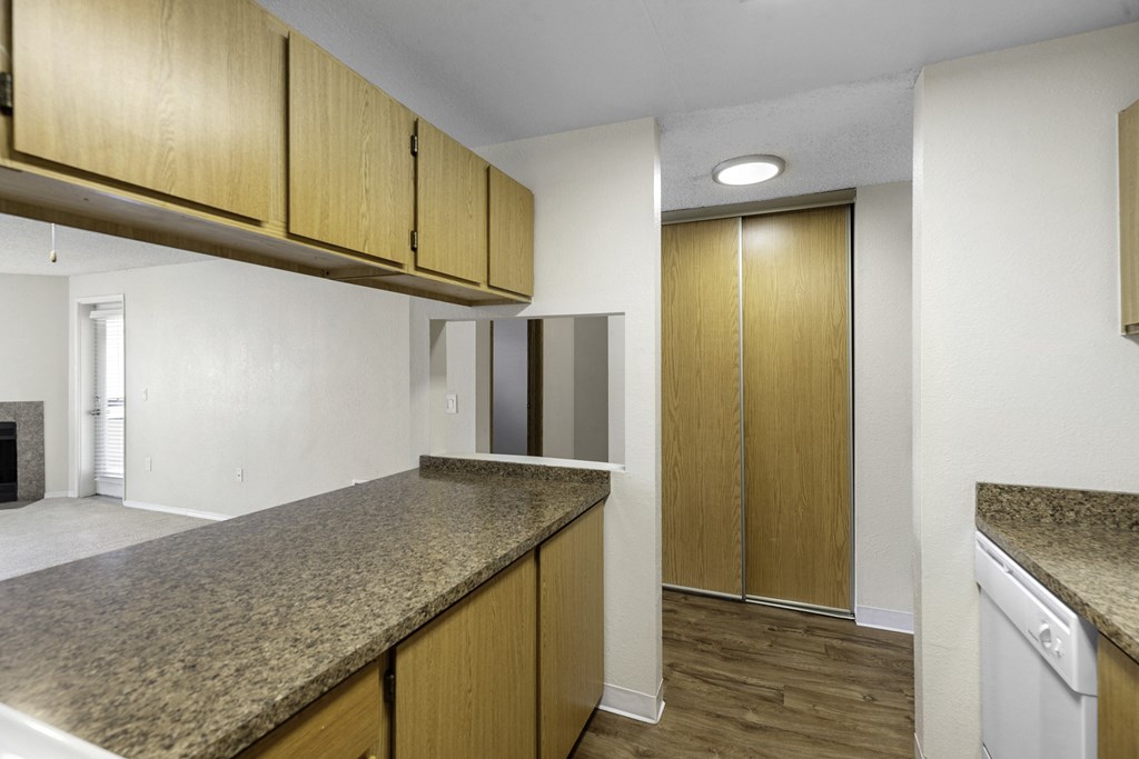a kitchen with granite countertops and wooden cabinets at Willows Court Apartment Homes, Washington