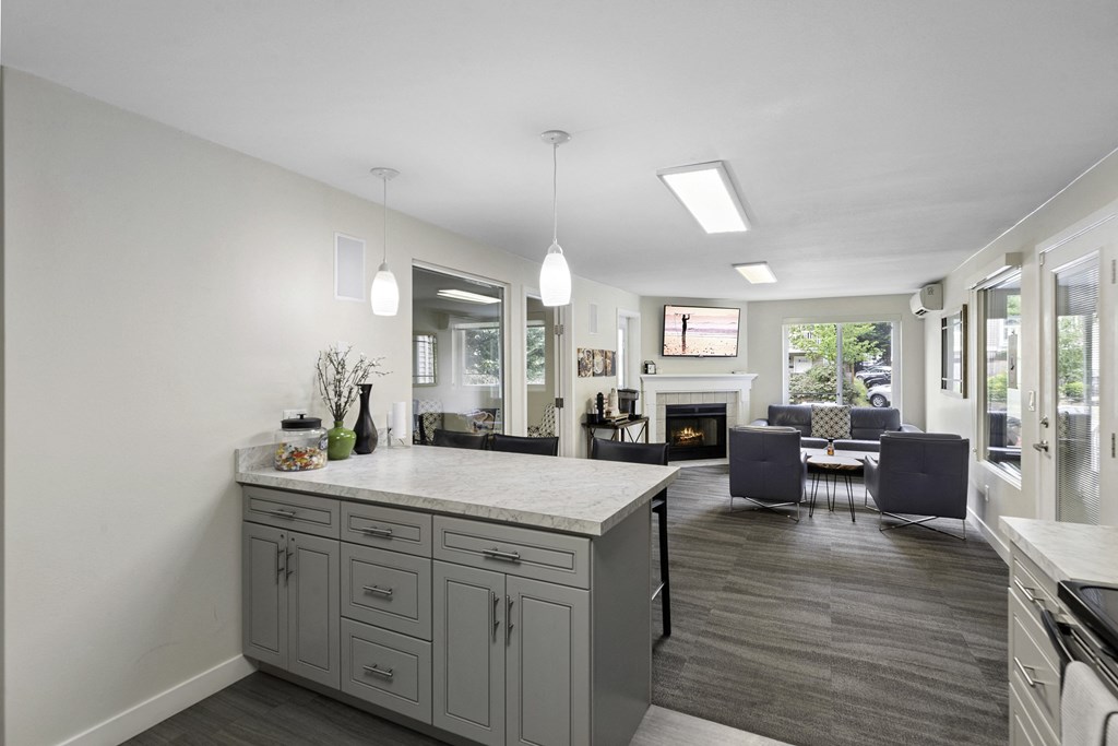 a kitchen with a large island and view into the living room in the background at Willows Court Apartment Homes, Seattle, 98125