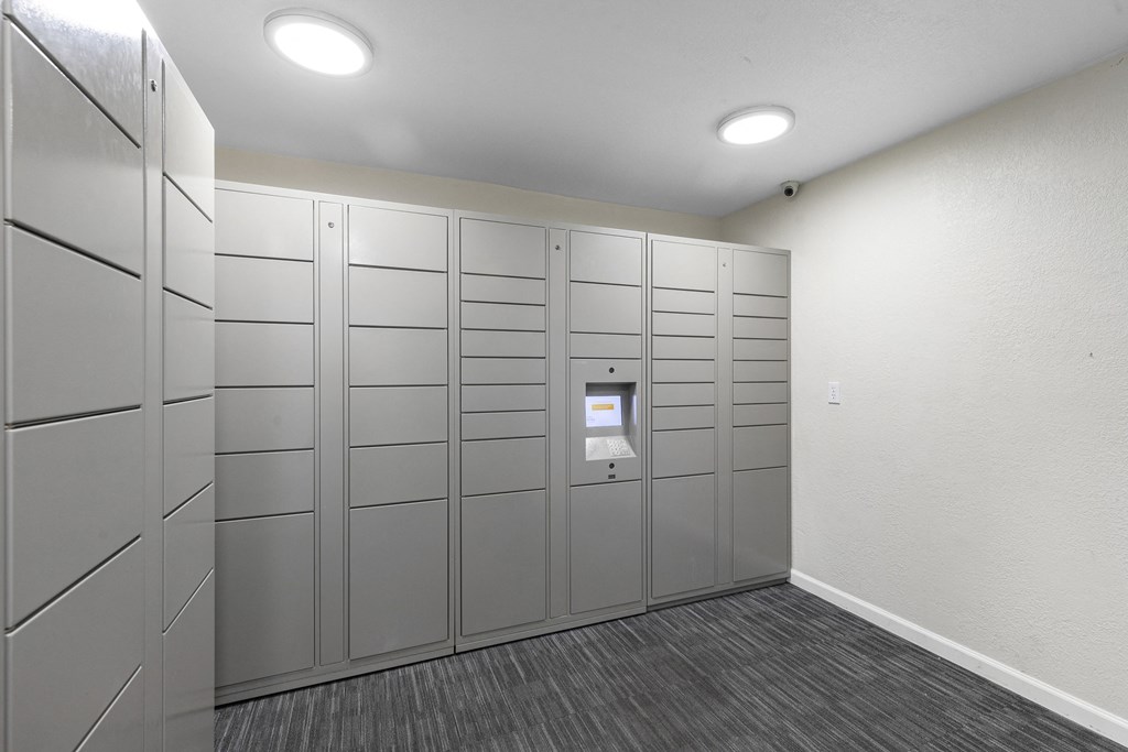 a row of Package Receiving  lockers in a room with a carpeted floor  at Park Edmonds Apartment Homes, Washington, 98026