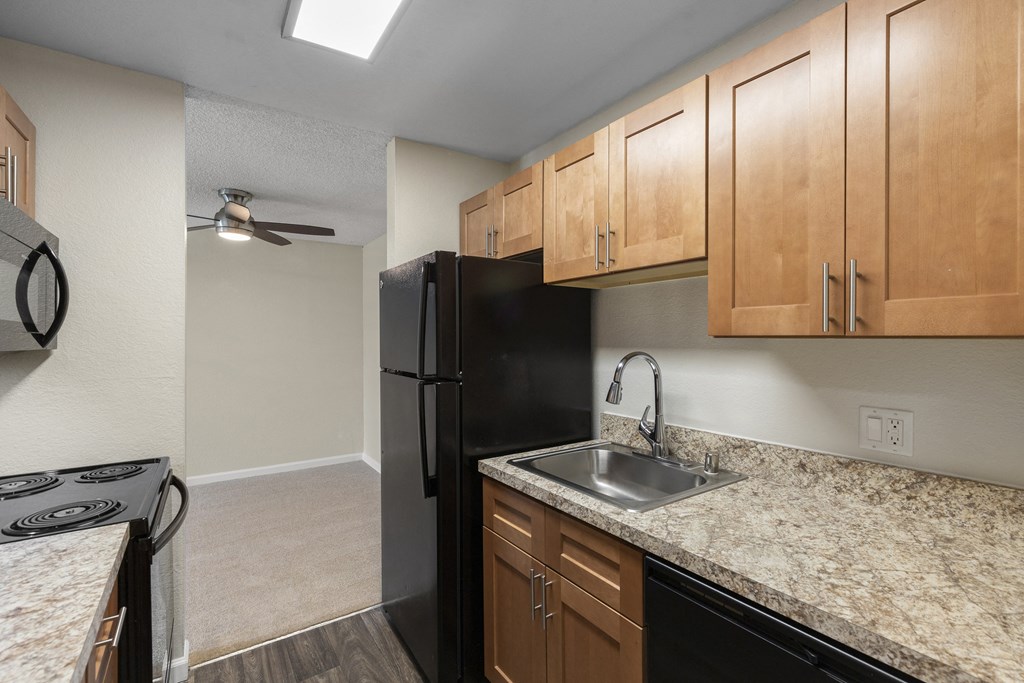a kitchen with wood cabinets and granite-look countertops  at Park Edmonds Apartment Homes, Edmonds, WA