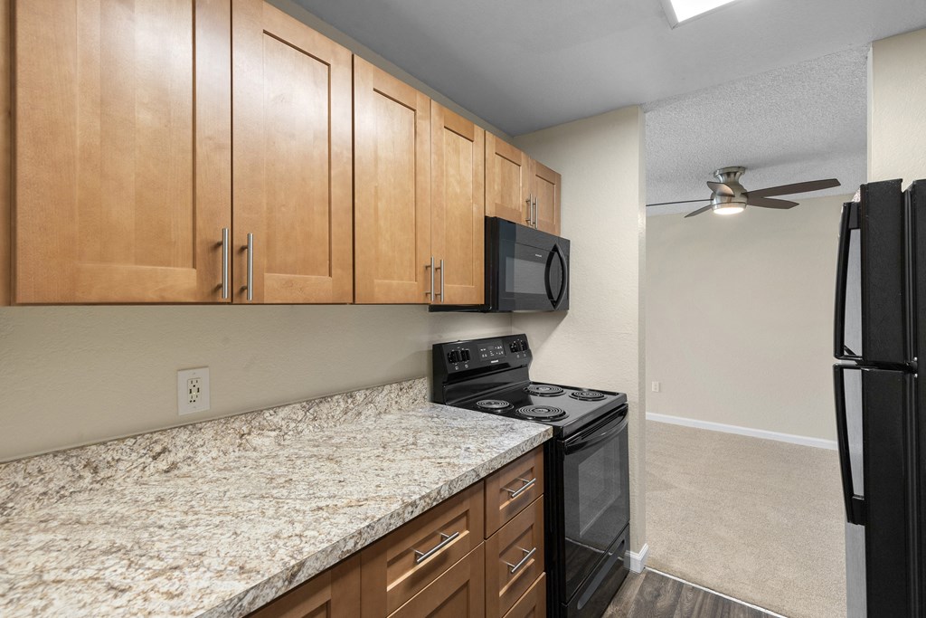 a kitchen with granite-look countertops and black appliances at Park Edmonds Apartment Homes, Edmonds, WA