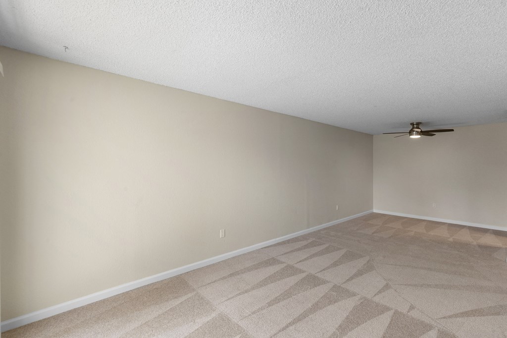 A Spacious Living room with a ceiling fan and tan carpet at Park Edmonds Apartment Homes, Edmonds, Washington