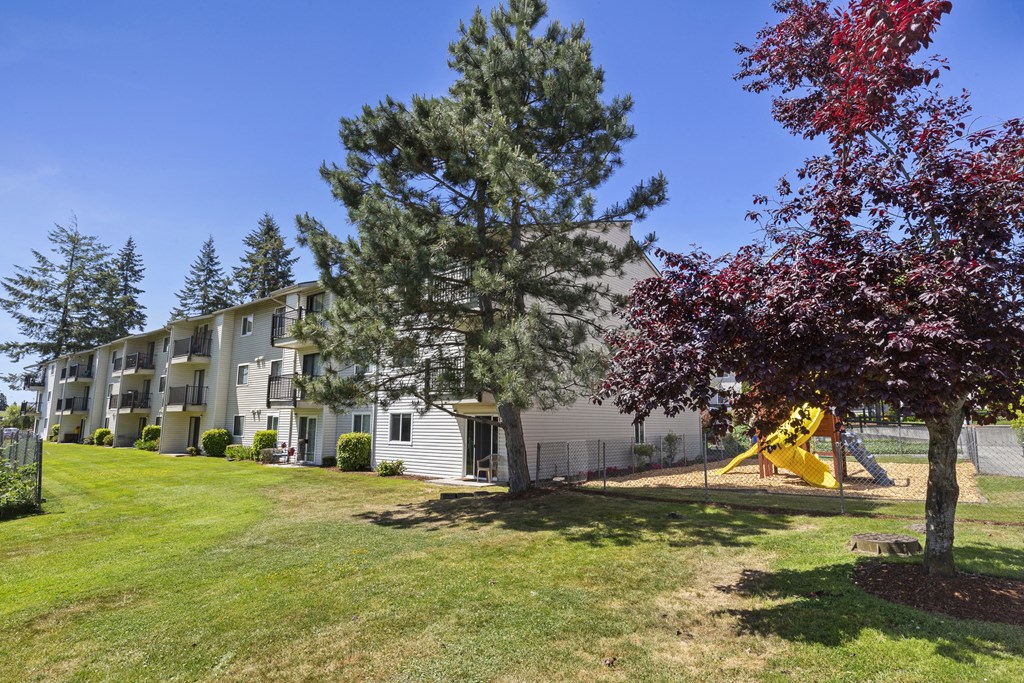 View of property playground with slide at Park Edmonds Apartment Homes, Edmonds, 98026