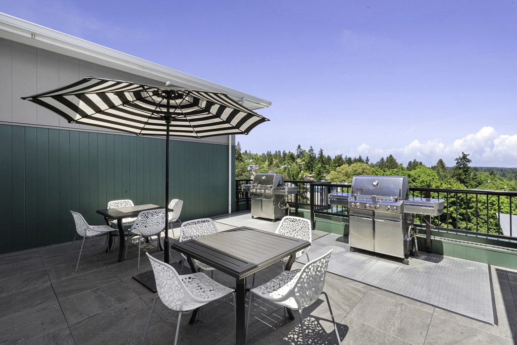 a patio with a table and chairs and a grill  at Sedona Apartments, Seattle, 98115