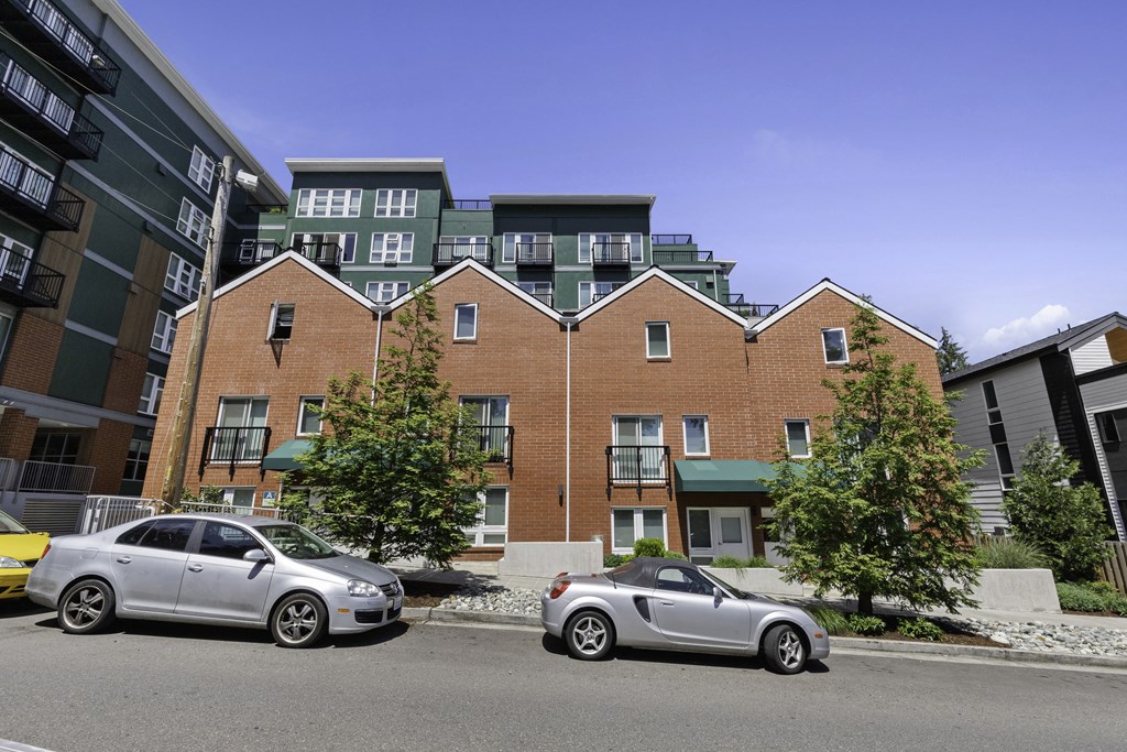 a view from the street of the property building with a green awning and trees at Sedona Apartments, Washington