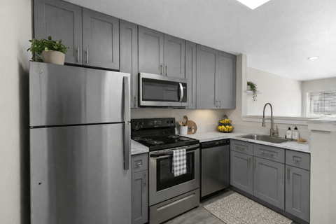 A modern kitchen with a stainless steel refrigerator and oven.