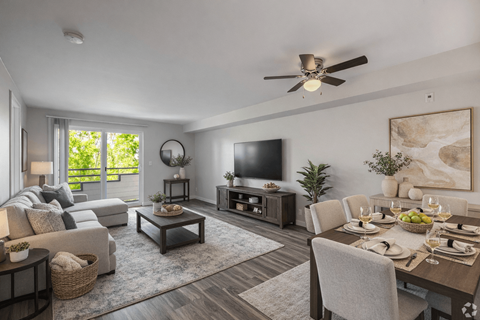 A modern living room with a dining table set for a meal.