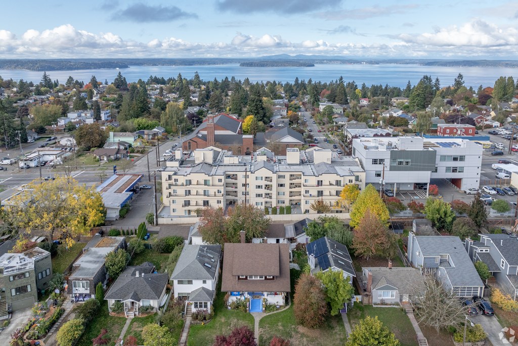 A small town with a large building in the center and a body of water in the background.