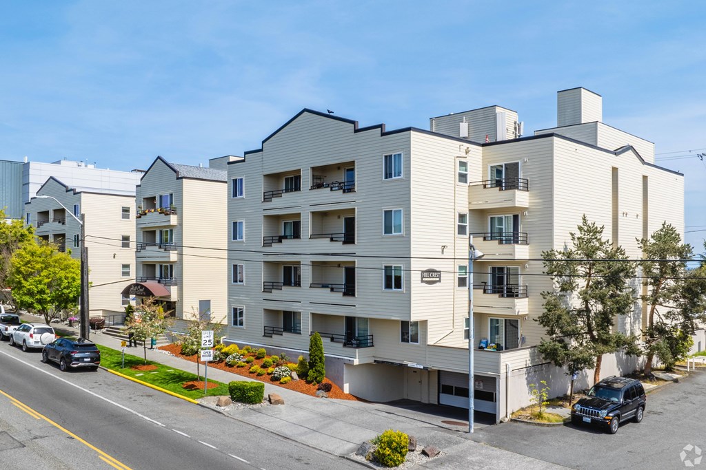 A modern apartment building with cars parked in front.
