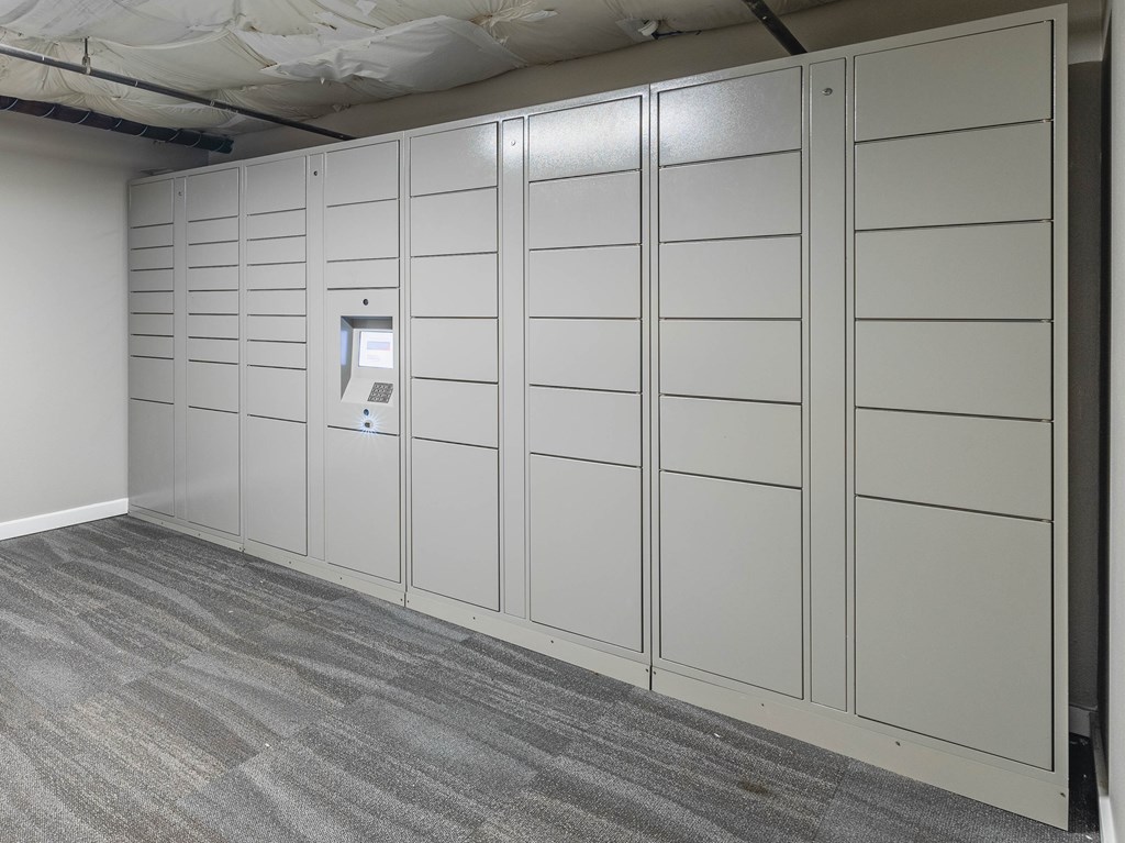 A wall of white lockers in a room.
