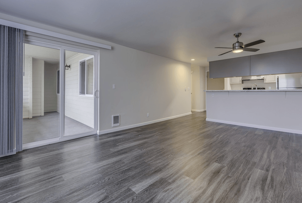 A room with a ceiling fan and a wooden floor.