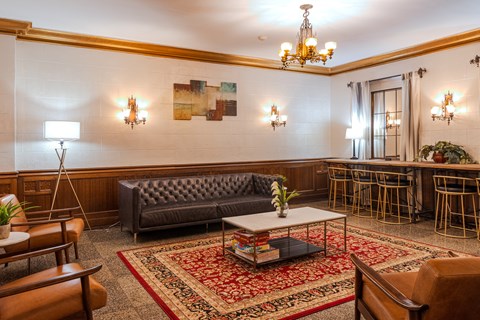 A living room with a grey sofa and a chandelier.