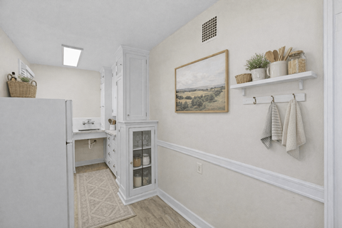 A kitchen with a white refrigerator and a white cabinet with glass doors.