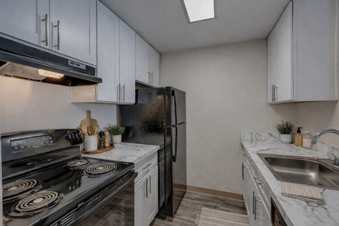 A kitchen with a black stove top oven and a black refrigerator.