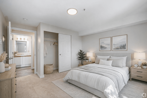 A well-lit bedroom with a large bed and a vanity table.