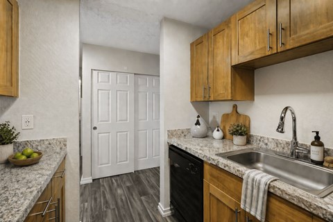 A kitchen with wooden cabinets and a white door.