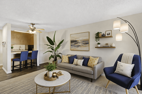 A living room with a blue chair and a grey couch.