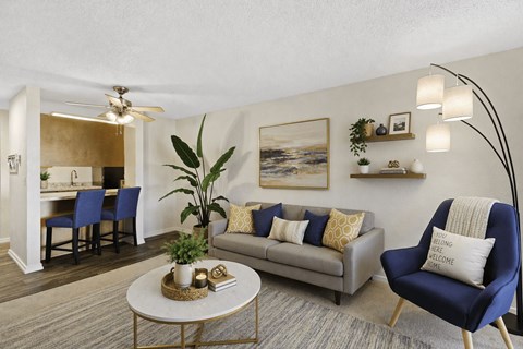 A living room with a blue chair and a grey couch.